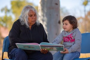 Graduate Joyce (left) shares a book.